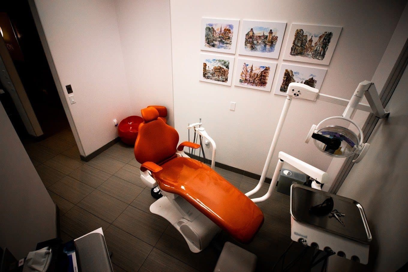 Treatment room with an orange dentist's chair at Carlton Dental, downtown Toronto